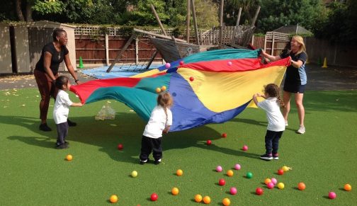 children holding a large piece of cloth