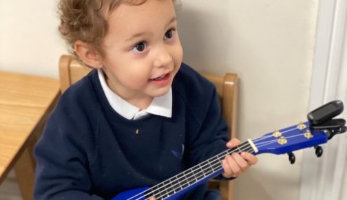 boy playing a toy guitar