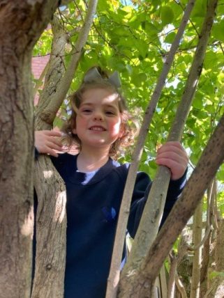 Young Peregrines Nursery pupil smiling in the trees