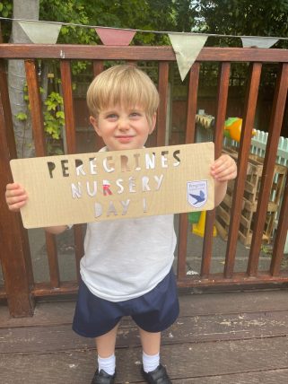Young Peregrines Nursery boy with a sign that reads Peregrines Nursery Day 1