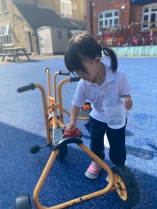 Peregrines Nursery girl playing with bike in playground