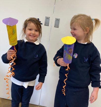 Two nursery children holding 3D rocket craft